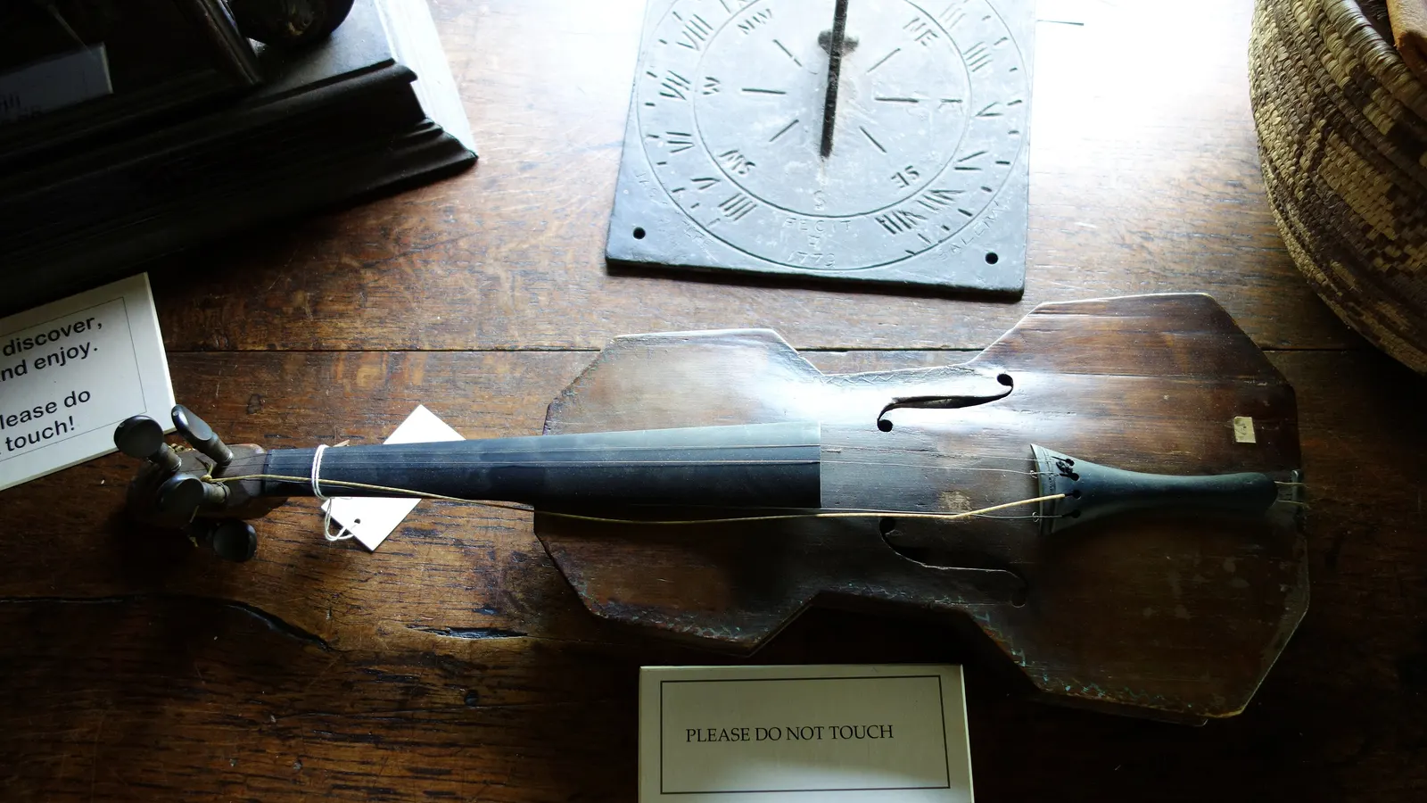 Violon populaire ancien en bois posé sur une table, dans une vitrine de musée